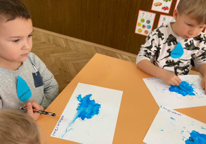 Zdjęcie przedstawia dzieci w trakcie rysowania